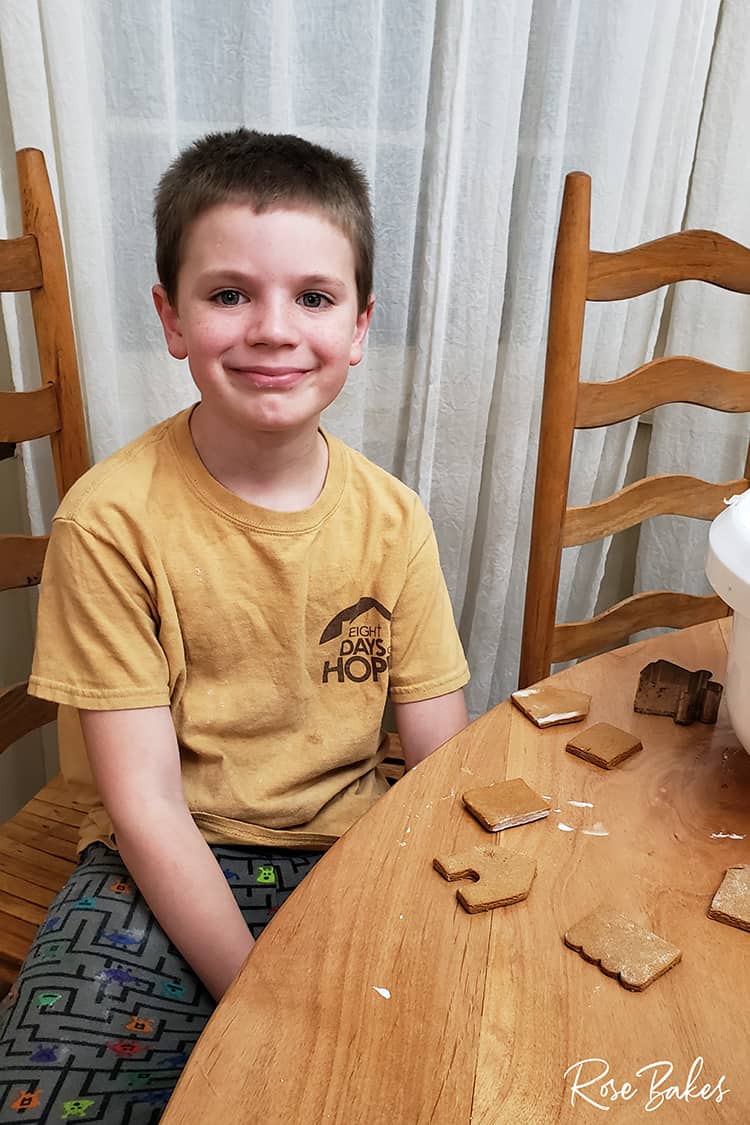 Kid building his gingerbread house