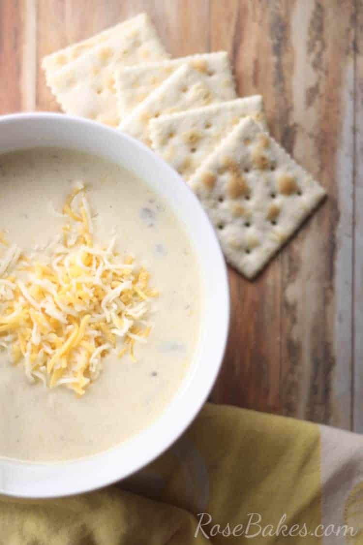 Bowl of Squash soup with cheese and saltine crackers