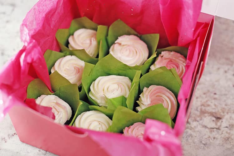 buttercream roses cupcakes in box with green tulip liners and tissue paper for cupcake bouquets