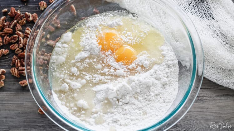 Clear mixing bowl with cake mix, eggs, and oil.