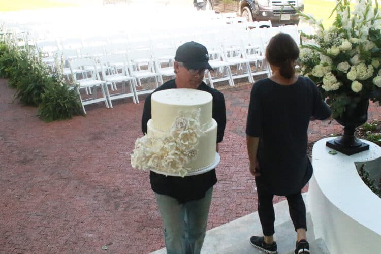 Man carrying 2 layers of wedding cake 
