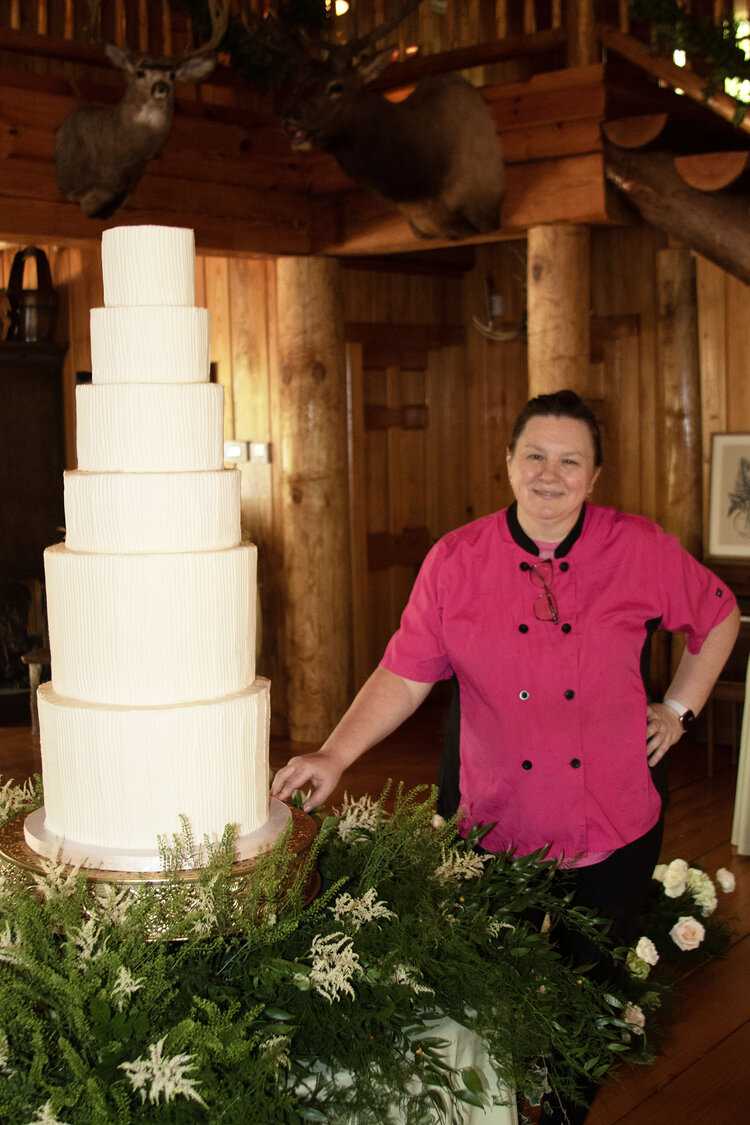 Rose standing next to a six tier ribbed buttercream wedding cake
