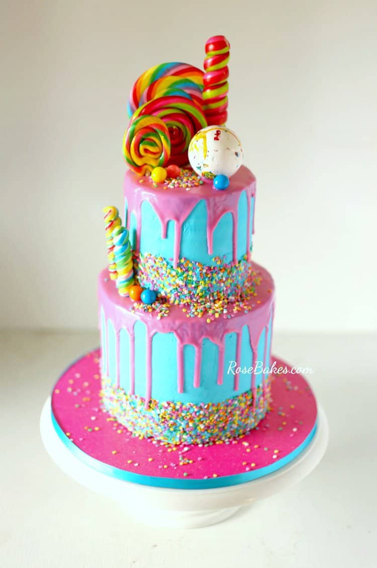 bright blue cake with pink drip and sprinkles and candy decorations