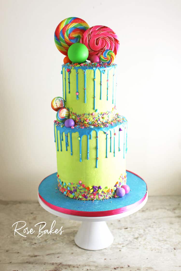 bright green tiered cake with blue drip and sprinkles and candy decorations