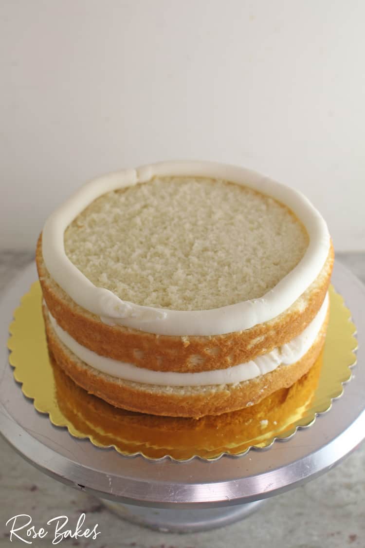 a layer of cake with a dam of stiff frosting around the top edge