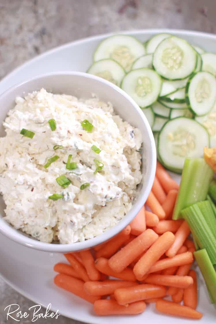 Bowl of Cottage Cheese Dip with slice cucumbers, celery, and carrots beside it.