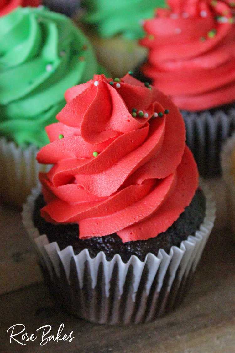 chocolate cupcake with bright red buttercream piped on top and sprinkles