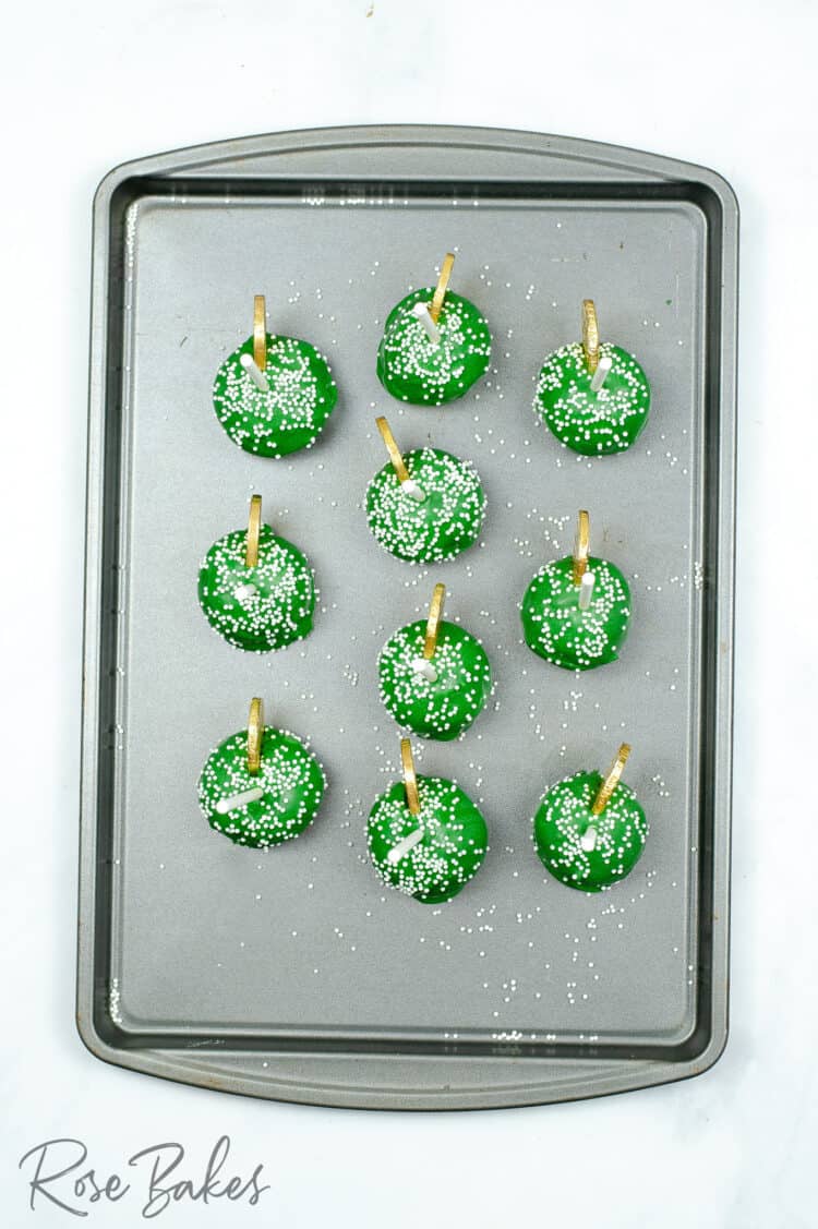 Top view of the finished green cake pops on a baking sheet.
