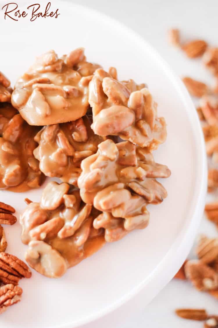 Multiple pecan praline clusters on white plate for serving 