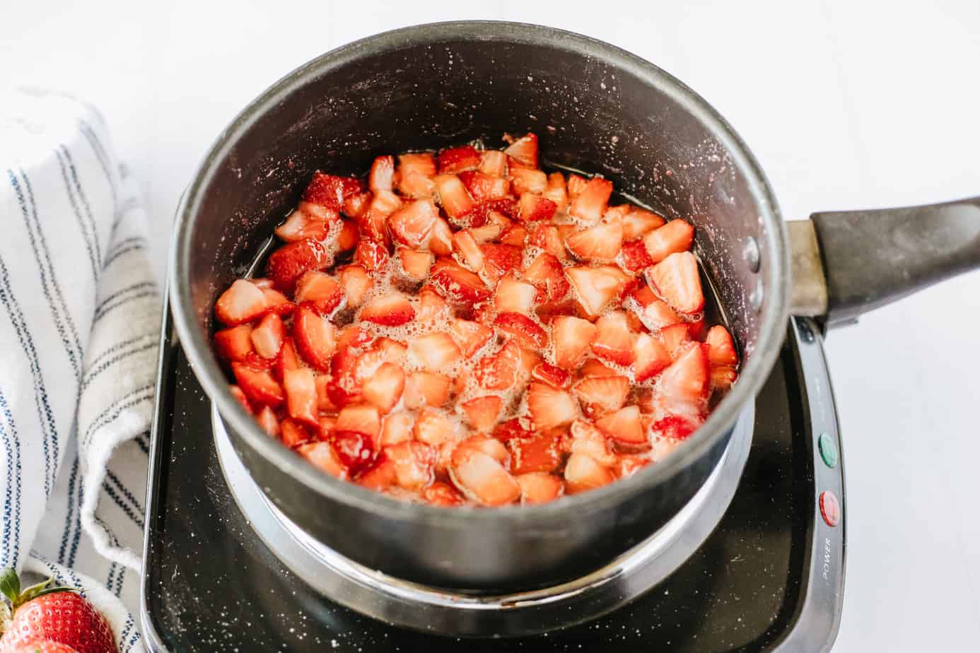 diced strawberries, sugar, lemon juice, vanilla  in a boiler on a electric cooktop cooking