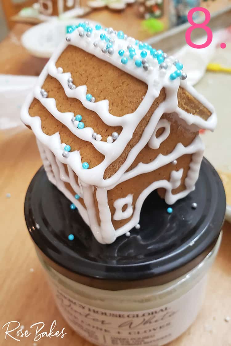 Mini gingerbread house drying on top of a lid
