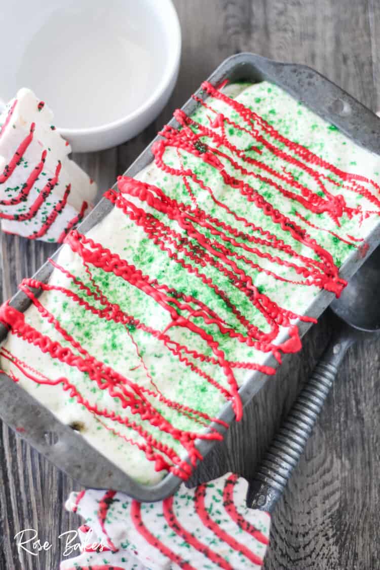 finished frozen pan of Little Debbie Christmas Tree Cakes Ice Cream with red candy melts drizzled and green sanding sugar on top