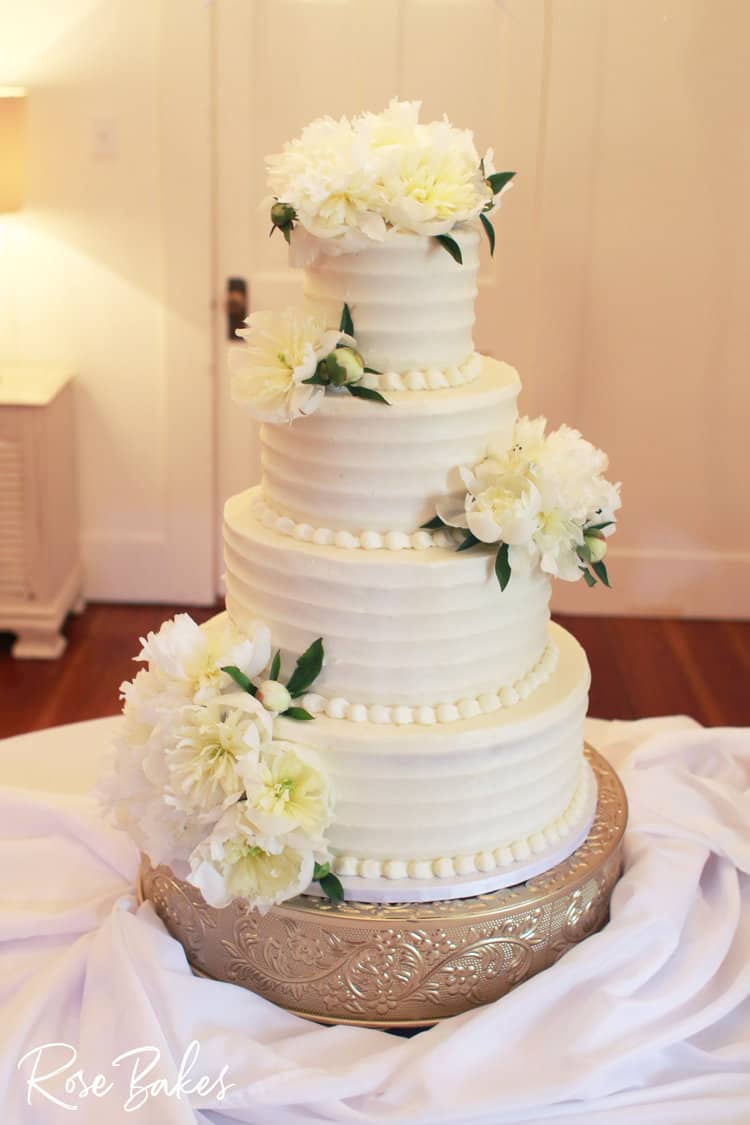 textured buttercream 4 tier wedding cake with flowers with gold flakes 