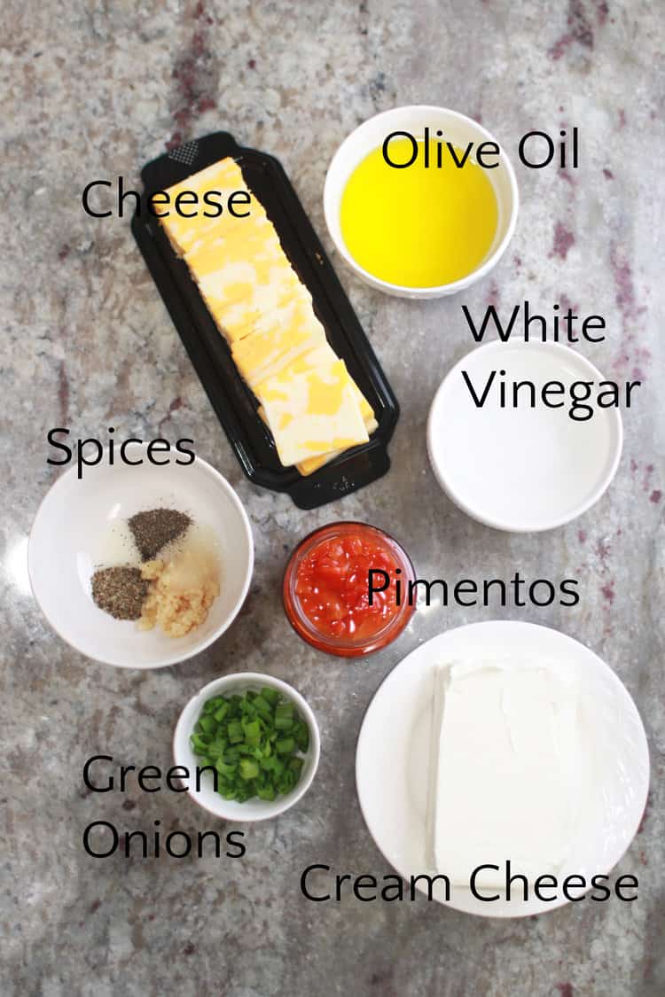 marinated cheese ingredients in white bowls on a gray counter