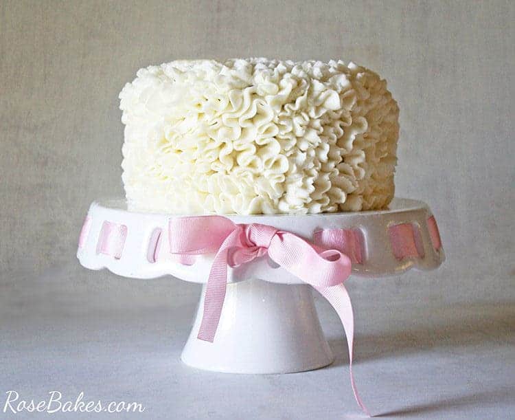 messy ruffles cake decorating video tutorial - messy ruffles cake on cake stand with pink ribbon