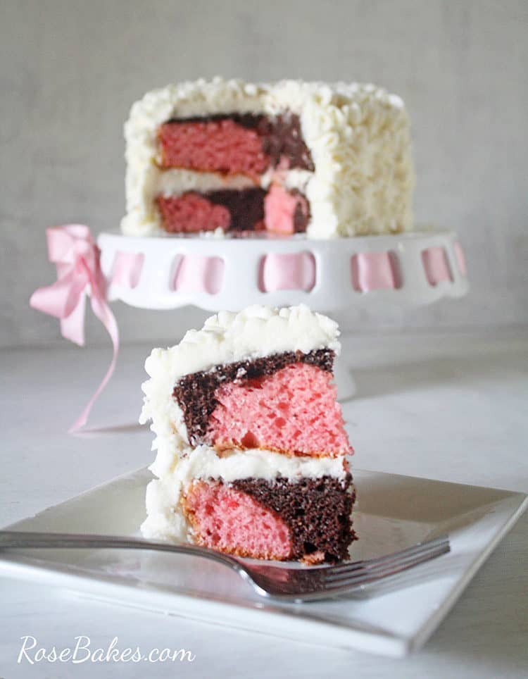 slice of messy ruffles cake - chocolate and strawberry swirled cake on plate with fork