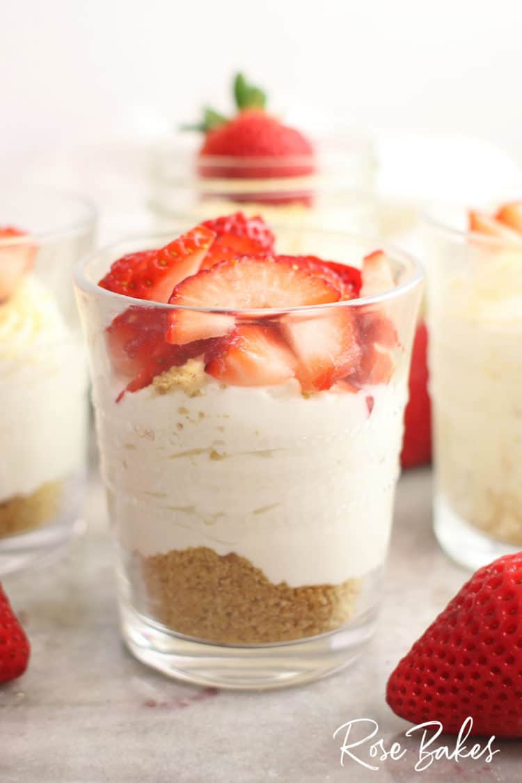 The creamiest No-Bake Cheesecake Cups Recipe in cups with strawberries on top 