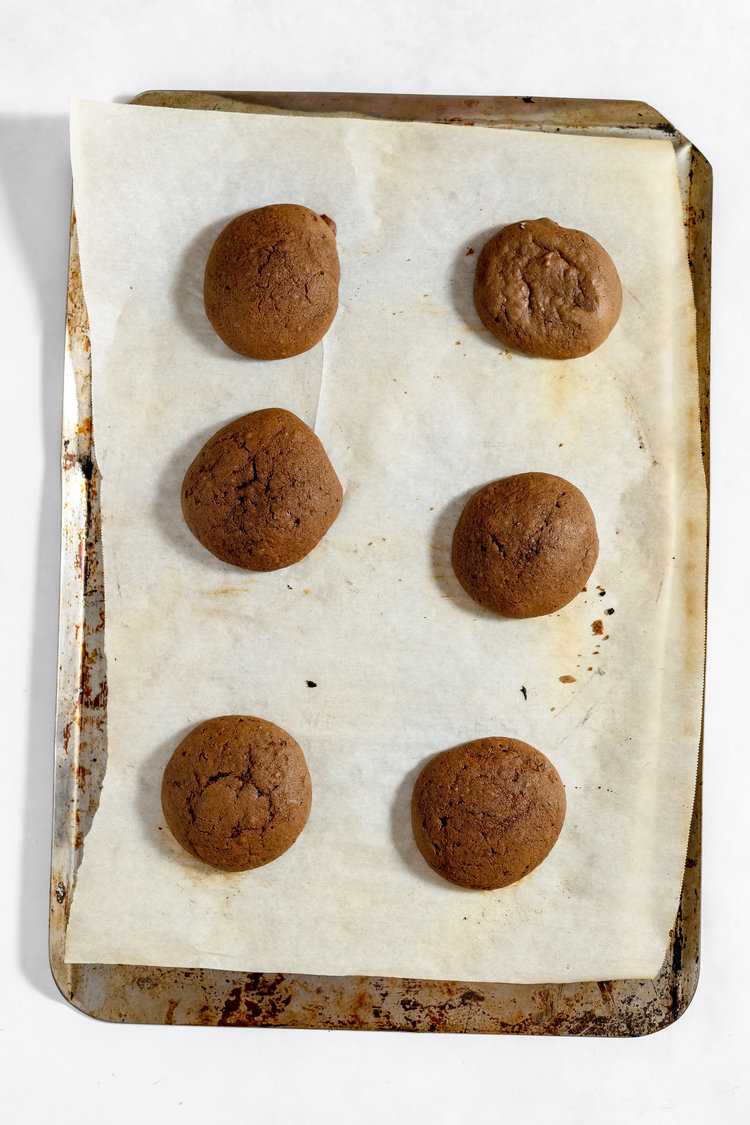 Baked whoopie pies on a parchment lined baking sheet.