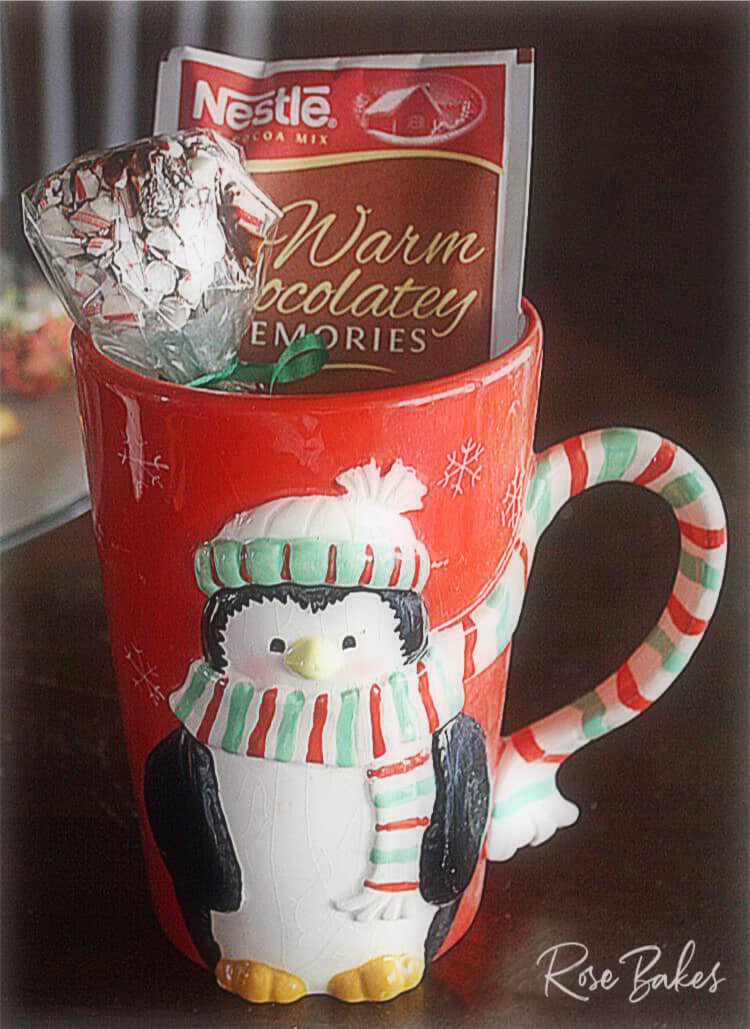 Wrapped Peppermint Dipped Marshmallows in Christmas mug with packet of hot cocoa mix for gift-giving