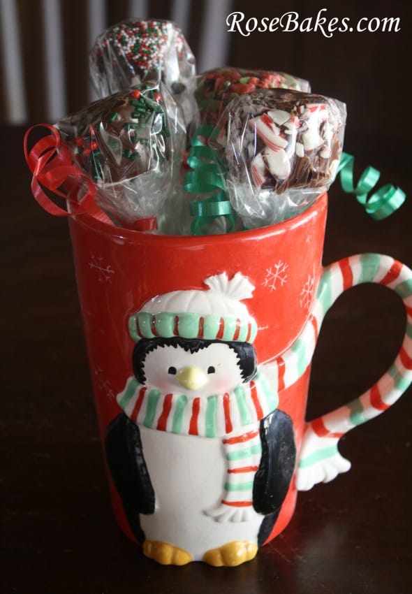 Several dipped marshmallows wrapped and in a Penquin Christmas mug for gift giving.
