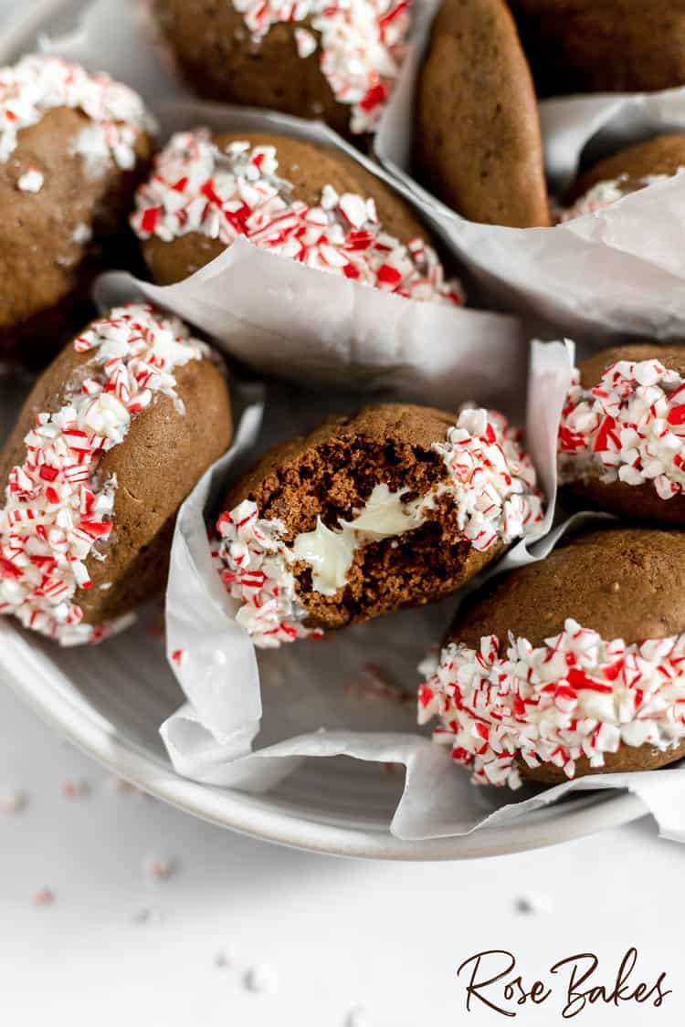 Close up of Chocolate Peppermint Whoopie Pies with the one in the center with a bite taken showing the buttercream filling.