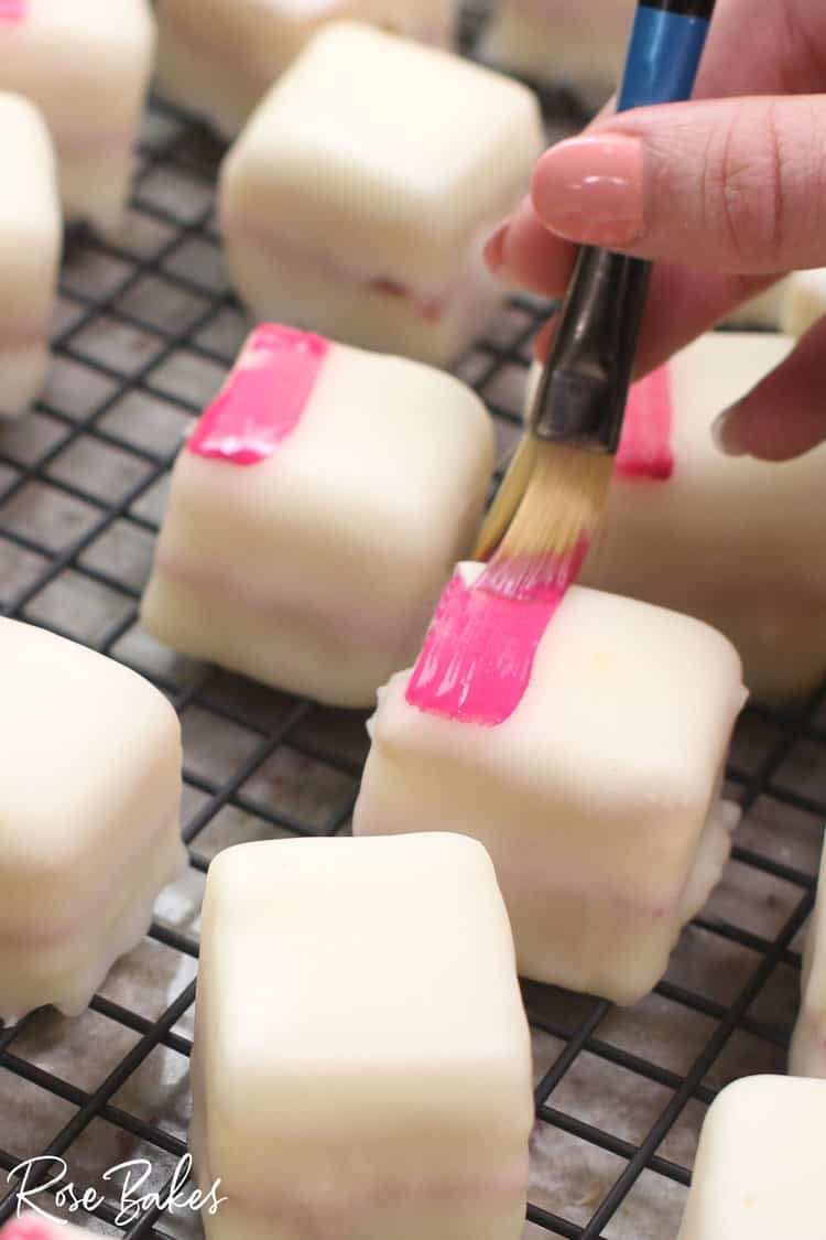 petit fours being painted with hot pink edible paint