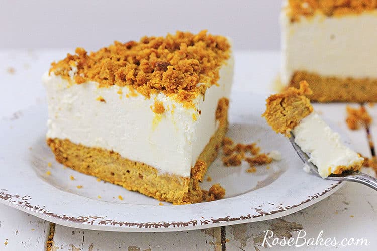 slice of pumpkin bread bottom cheesecake on a white plate with a bite missing
