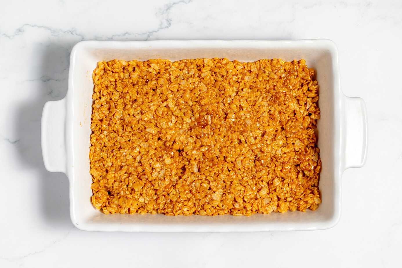 marshmallow and rice cereal mixture pressed into white baking dish