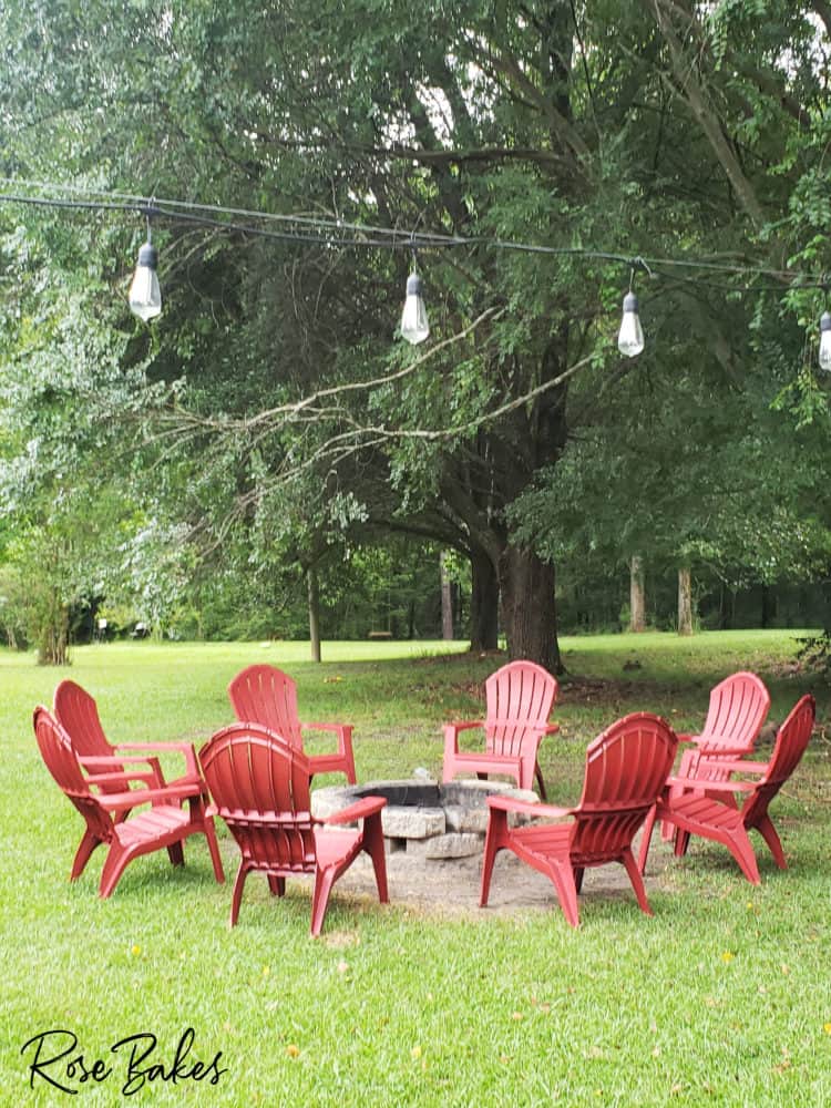 backyard with firepit and red adirondack chairs