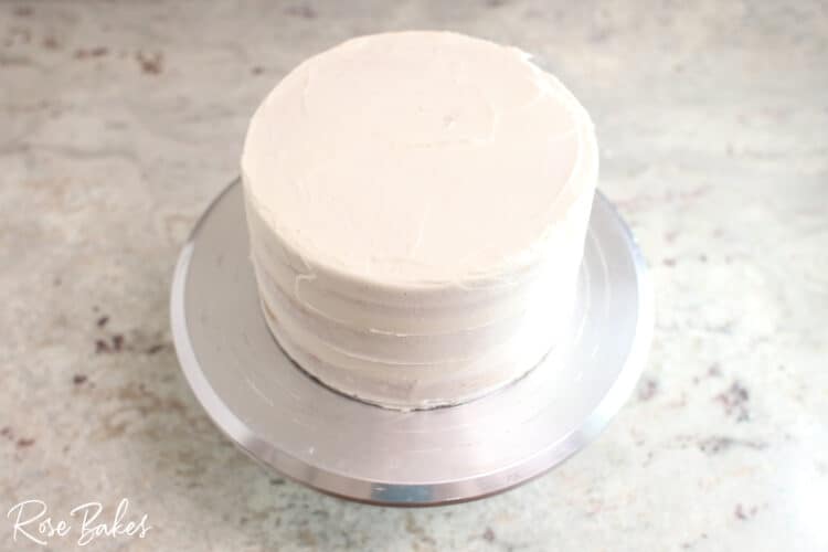crumb coated  buttercream 1 tier cake on silver cake stand