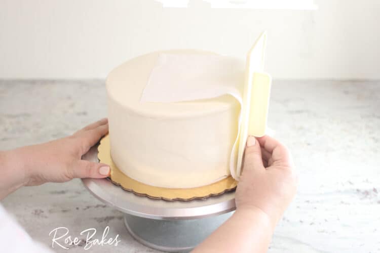 viva towel being used to smooth sides of buttercream icing cake 