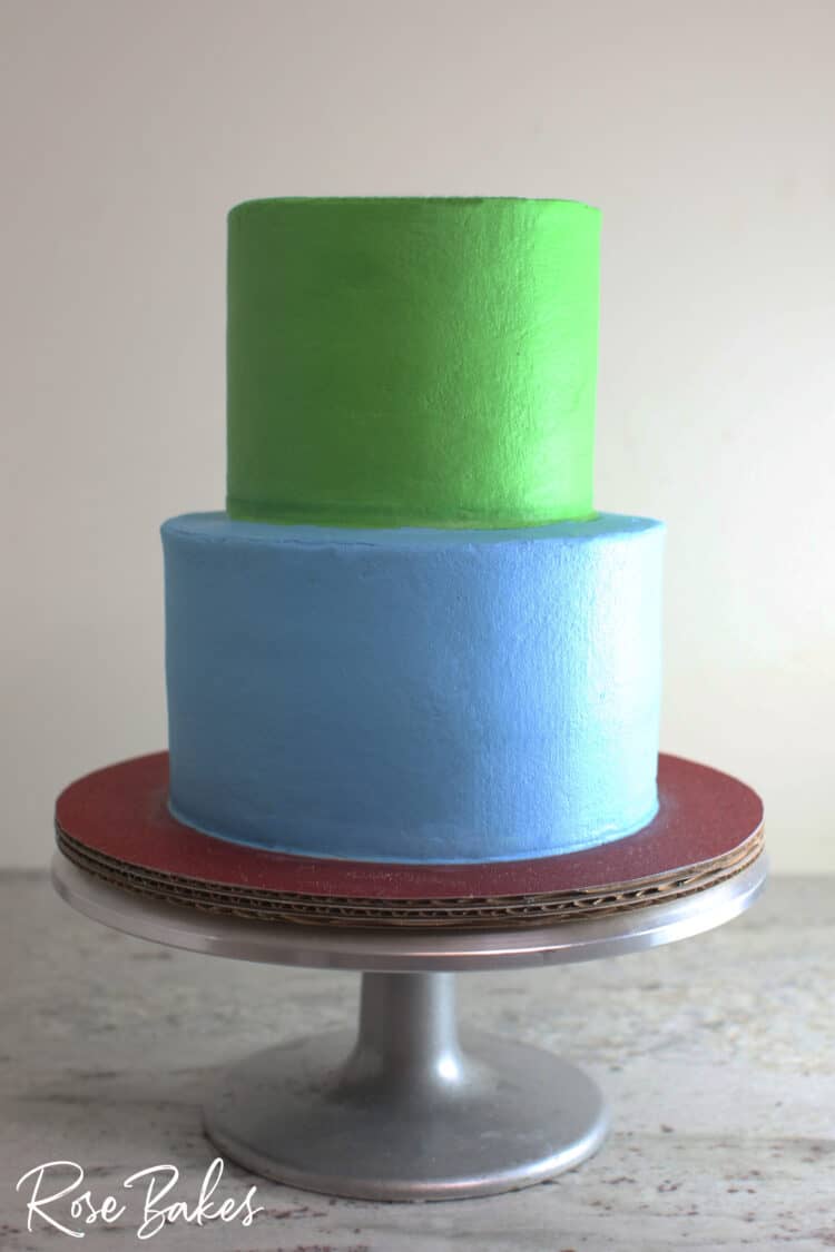 2 tier buttercream icing cake bottom tier deep sky blue top tier grass green with sharp edge