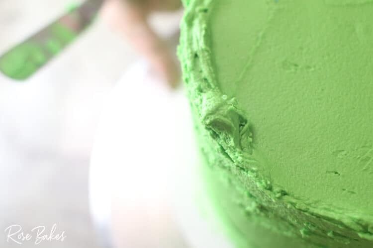 up close look at edges of green icing not yet smooth for sharp edge look