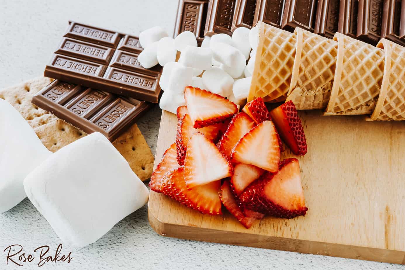 add waffle cones filled with mini marshmallows and sliced strawberries to the side next to the hershey bars