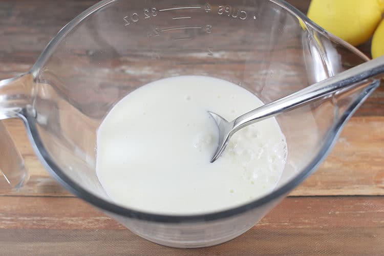 how to make buttermilk - spoon in cup of milk stirring in lemon juice