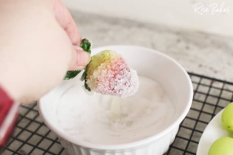 Dipping a strawberry into sugar