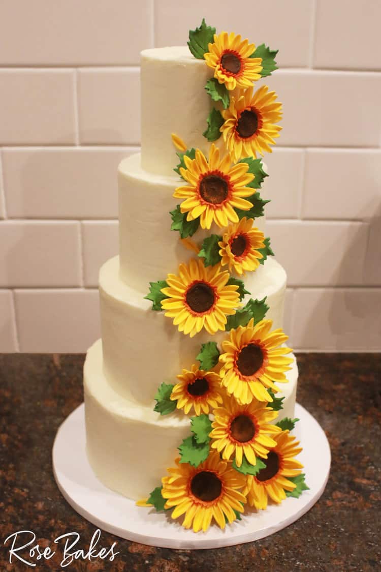 cascading sugar sunflowers on 4 tiered white cake.