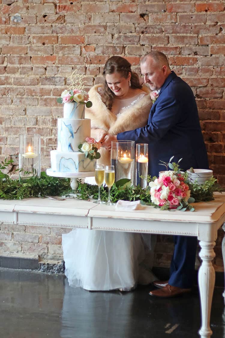 Susan and Stephen cutting the Marbled Fondant Wedding Cake with Navy Gold and Pink 