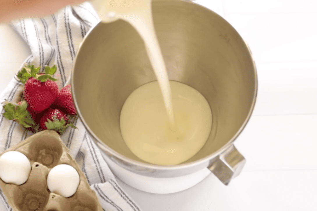 pouring whipping cream into a mixer bowl