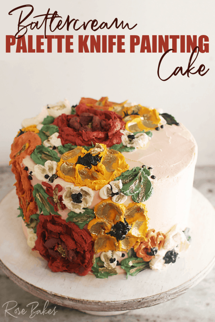 Cake frosted white with green leaves and red, yellow, and white buttercream flowers created with palette knives on one side of the top of the cake and cascading down the side of the cake.  Text at the top of the image reads "Buttercream Palette Knife Painting Cake"