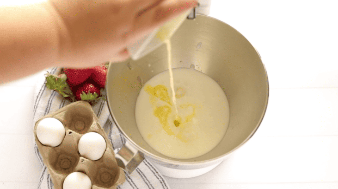 adding melted butter to whipping cream to a mixing bowl
