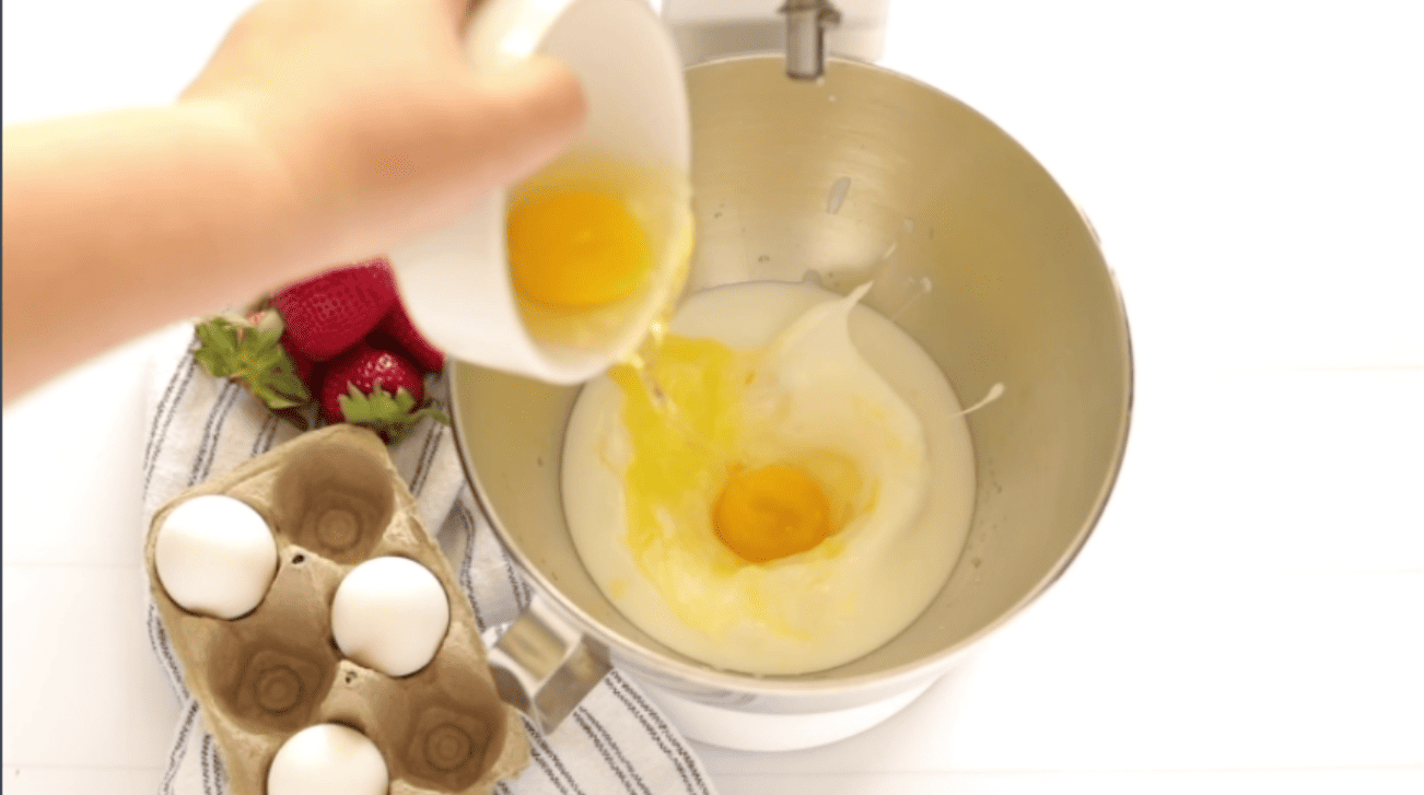 adding eggs to the melted butter and whipping cream to a mixing bowl