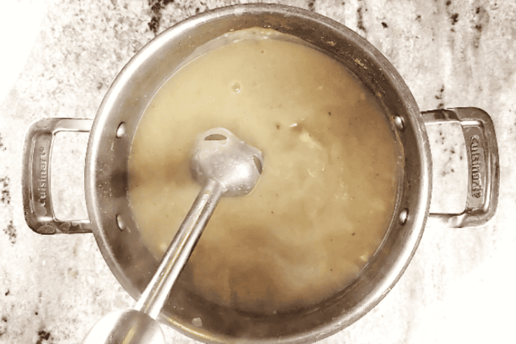 blending potato soup with cream cheese with a stick blender