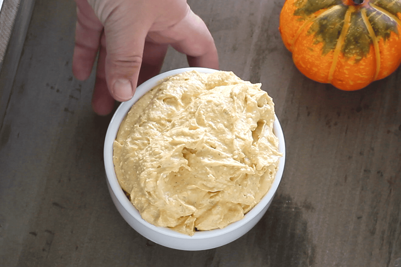 placing a bowl of pumpkin dip on the tray