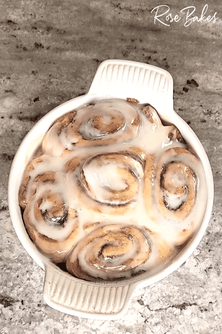 white baking dish filled with Cinnamon Rolls with Heavy Cream and topped with Icing